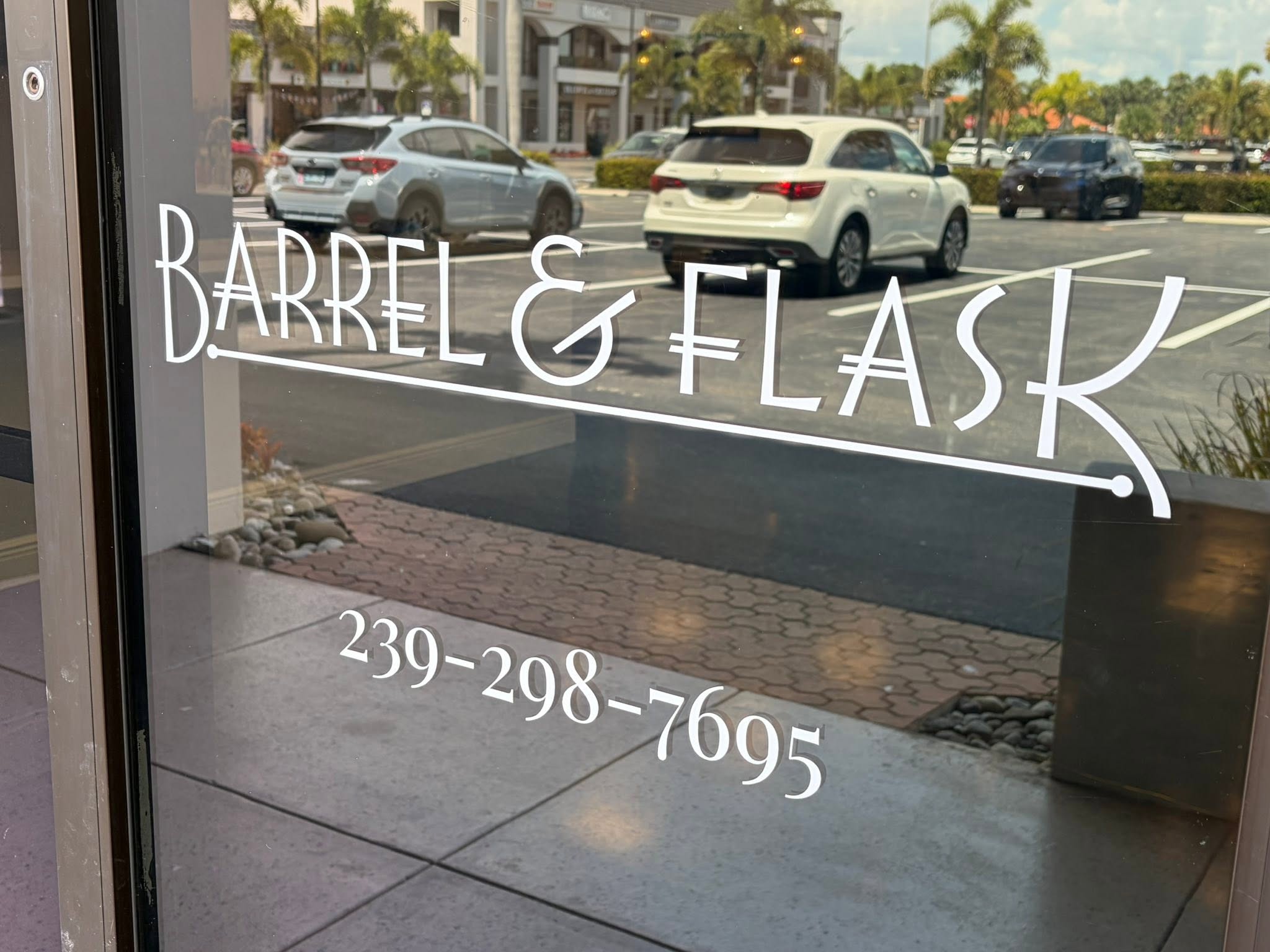 The Barrel & Flask storefront glass door in Liberty Plaza, Naples